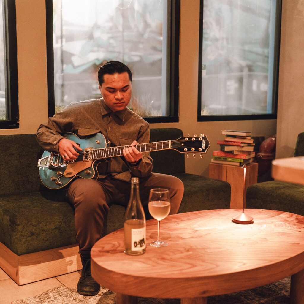 Picture of Troy Truong Onbar on a guitar
