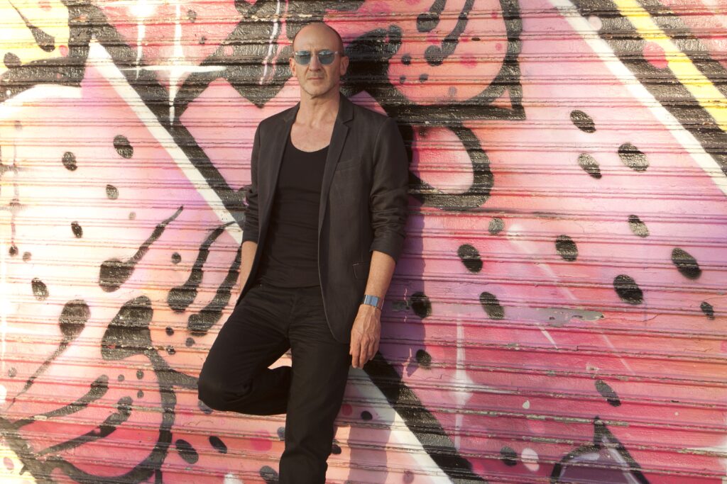 Eddie Cohn leaning on a graffiti wall